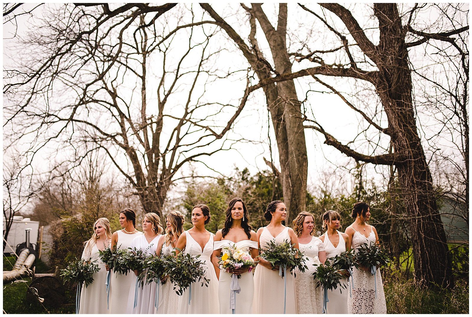 Bridesmaids in all white, gorgeous greenery bouquets by Homegrown Florist