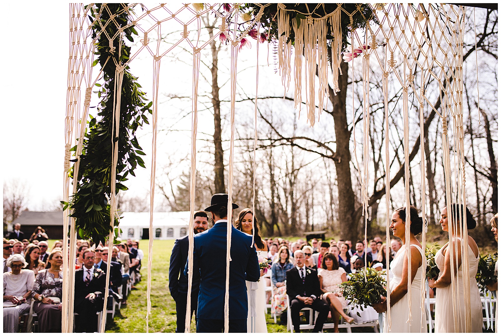 Bride and groom under their Macrame and floral bohemian alter. 